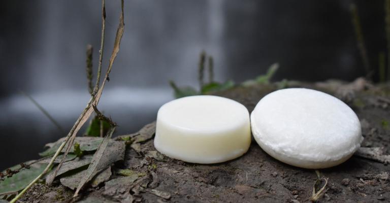 Tangie natural shampoo and conditioner bar next to a waterfall